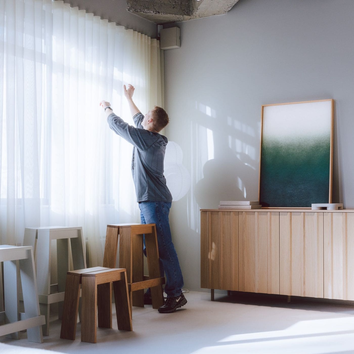 Modern interior with wooden furniture and soft acoustic images on the wall enhancing light and atmosphere.